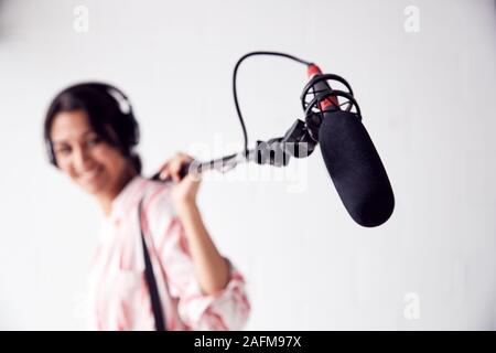 Ritratto di donna Sound Recordist tenendo il microfono su Video produzione di pellicola in bianco Studio Foto Stock