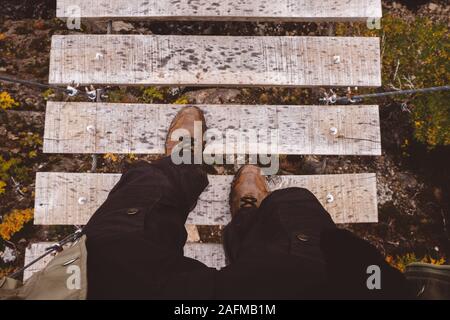 Persona di raccolto camminando sul ponte di corde in natura Foto Stock