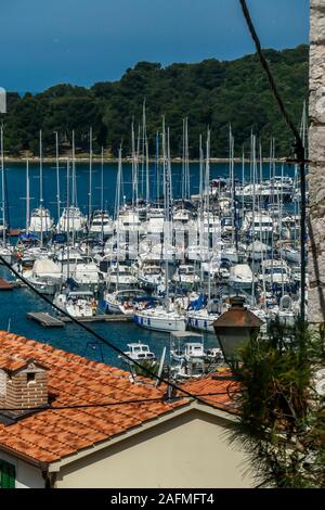 Una vista ravvicinata sul porto da una collina. Le righe dei docks di attesa per le barche e yacht di ancoraggio. Ci sono un sacco di case intorno al porto. In th Foto Stock