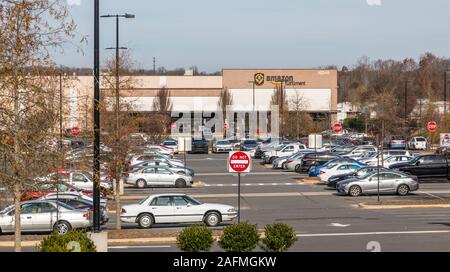 CHARLOTTE, NC, Stati Uniti d'America - 8 dicembre 2019: un centro di distribuzione Amazon su Wilkinson Blvd., con parcheggio pieno di veicoli dei dipendenti. Foto Stock