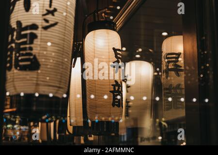 Vista attraverso il vetro dell'illuminato lanterne giapponesi all'interno di un ristorante. Foto Stock