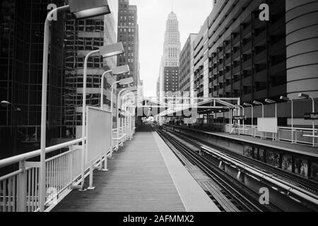 Chicago, Illinois, Stati Uniti d'America - 1996: Archiviazione in bianco e nero vista del centro della città di architettura e di elevata treno in transito le vie del Washington pozzetti stazione. Foto Stock