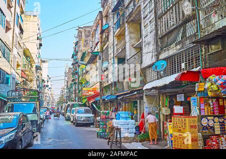 YANGON, MYANMAR - 17 febbraio 2018: piani terra di edifici vive in strada di Chinatown sono occupati con diverse bancarelle del mercato, offerin Foto Stock