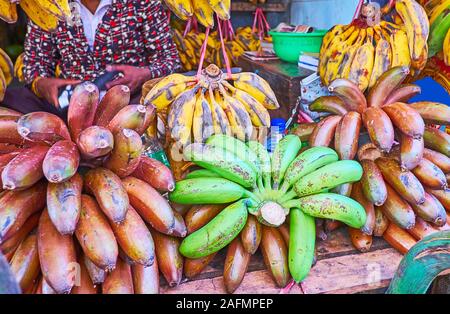 Close-up di giallo, rosso e verde le banane nel mercato di strada di stallo Chinatown di Yangon, Myanmar Foto Stock