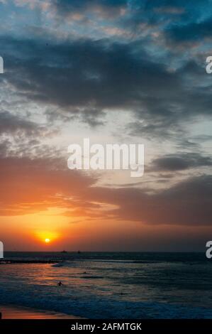 Mancora, Perù - aprile 2019 sulla spiaggia durante il tramonto con la luce del sole che riflette in mare Foto Stock