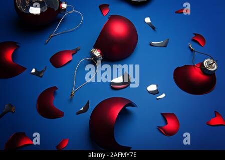 Rotture di rosso le palle di Natale sul classico sfondo blu. Colore dell'anno 2020, classic blu. Foto Stock