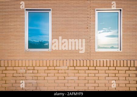 Semplice facciata in mattoni con due finestre verticali. Foto Stock