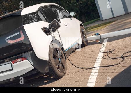 Tramsportation. Elcetric auto sulla stazione di carica nessun popolo potenza in ev plug Foto Stock