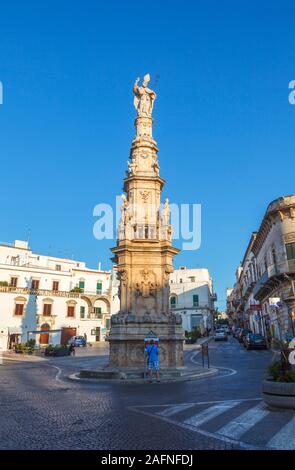 Statua di sant Oronzo (Saint Orontius) su una colonna di Ostuni piazza nel centro storico di Ostuni, nella luce della sera Foto Stock
