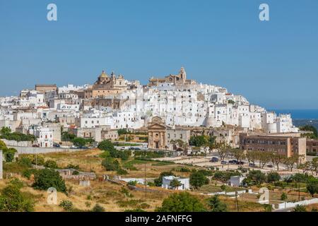 Vista di Ostuni, un bianco storica città sulla collina di Brindisi, puglia, Italia meridionale, con luccicanti edifici imbiancati in estate Foto Stock