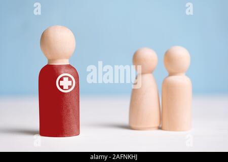 Il concetto di un maschio e femmina medico. Statuine di legno su uno sfondo blu. Close up. Foto Stock