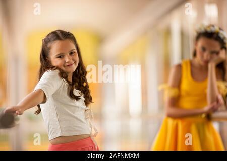 Ragazza broncio come lei guarda la sua felice sorella. Foto Stock