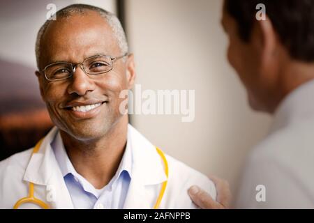 Ritratto di maschio maturo medico, come collega parla di lui. Foto Stock