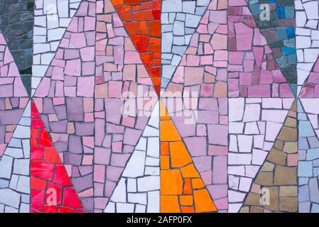 Mosaico di pietra decorazione colorata pattern in forme triangolari sulla parete Foto Stock