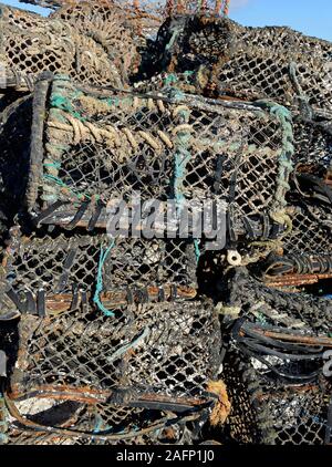 Pile di grandi dimensioni di cantre o pentole usate dai pescatori costieri per la cattura di granchi e aragoste sulla banchina a Paignton, Devon, Regno Unito. Foto Stock