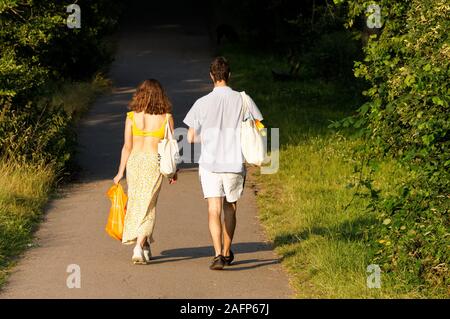 Indietro vista di giovane coppia camminando nel parco a Hampstead Heath a Londra, Inghilterra Regno Unito Regno Unito Foto Stock