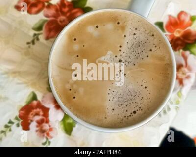 White tazza di cappuccino con schiuma sul tavolo della cucina al mattino . Vista dall'alto. cappuccino caffè nella tazza vicino. bevanda cappuccino con schiuma Foto Stock