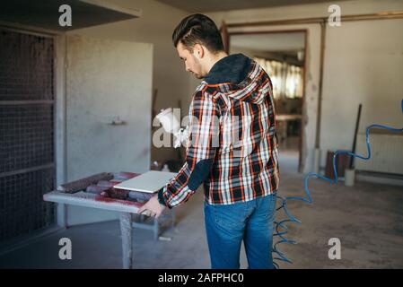 Artigiano sprey verniciatura mobili nella sua bottega. Foto Stock