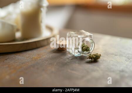 Marihuana fiore sul tavolo e in un contenitore di vetro Foto Stock