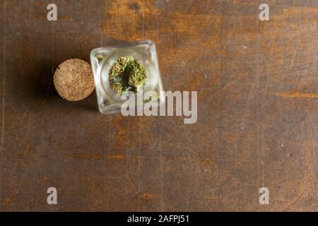 Pezzo di marihuana fiore all'interno di un vetro in vista superiore Foto Stock