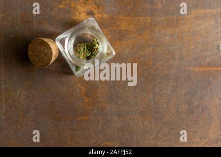 Pezzo di marihuana fiore all'interno di un vetro in vista superiore Foto Stock