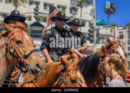 Huntington Beach, Stati Uniti d'America - Luglio 03, 2017: Equestre degli ufficiali di polizia da Huntington Beach e Santa Ana i dipartimenti di polizia di interagire con i turisti Foto Stock