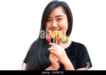 Dolci caramelle forma di cuore pieno di colore in mano alle donne su sfondo sfocato, impostare la caramella di colore arcobaleno lecca-lecca, dono per il giorno di san valentino amore concepton Foto Stock