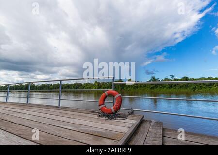 Ciambella arancione anello con lo sfondo del fiume in South American Jungle Foto Stock