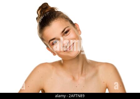 Ritratto di giovane donna sorridente senza trucco e moli sul suo torace su sfondo bianco Foto Stock