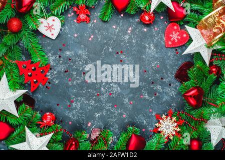 Natale o Capodanno in legno scuro, sfondo nero incorniciate della scheda con decorazioni di stagione, spazio per un testo, vista da sopra Foto Stock