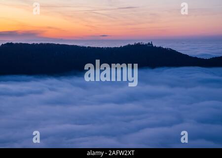 Germania, magica vista aerea sopra le nuvole di nebbia nella valle del Giura Svevo natura paesaggio al tramonto con il cielo arancione vicino a Stoccarda con vista al castello Foto Stock