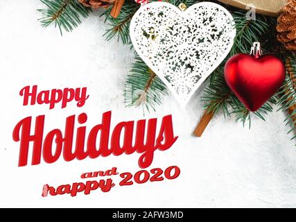 Piano di composizione dei laici con il lettering, buone feste e felice 2020. Telaio con albero di natale rami, decorazioni di Natale, sfere, cuori Foto Stock