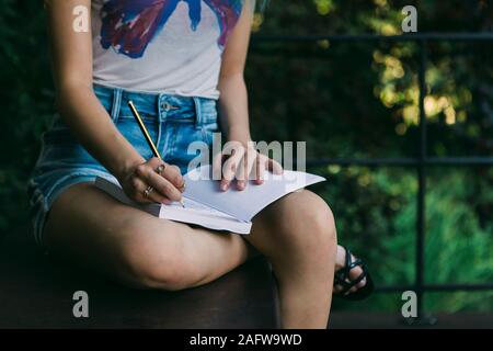 Giovane donna iscritto nel journal Foto Stock