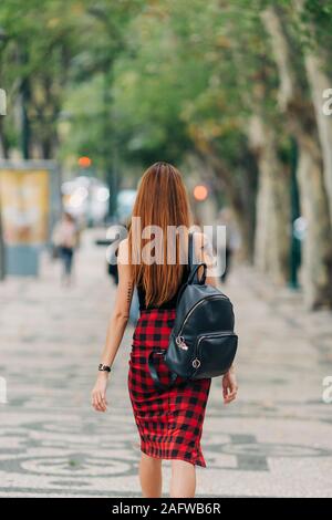 Giovane donna con zaino passeggiate nel parco urbano Foto Stock