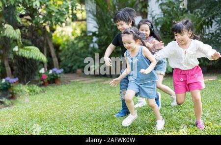 Asian giochi per bambini all aperto con gli amici. i bambini giocano a calcio a calcio al parco della natura. Foto Stock