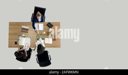 Vista superiore della gente di affari si stringono la mano dopo la chiusura a tenuta di una trattativa. Angolo di alta vista di imprenditrici handshake dopo la conclusione di accordo commerciale. Foto Stock