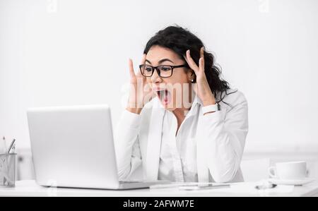 Scioccato sorpreso donna latina utilizzando pc e urlando Foto Stock