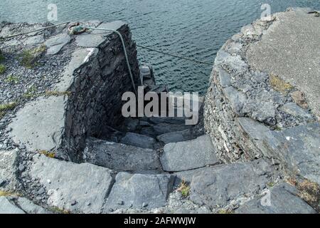 L'ardesia passi verso il basso per un ormeggio sul Easdale isola al largo della costa occidentale della Scozia Foto Stock