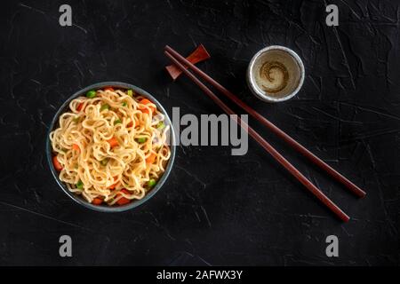 Tagliatelle istante con verdure, con amore e bastoncini, girato dalla parte superiore su uno sfondo scuro con un posto per il testo Foto Stock