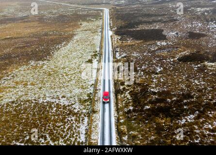 Red Royal Mail post van guida su strade coperte di neve strada rurale attraverso Glen Quaich in Scozia, Regno Unito Foto Stock