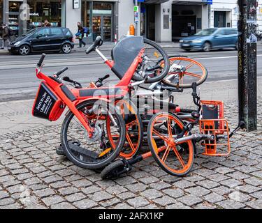 Cittadino di protesta, un mucchio di biciclette e scooter- i berlinesi oggetto per il numero crescente di noleggio di biciclette e scooter sui marciapiedi della città di Berlino Foto Stock