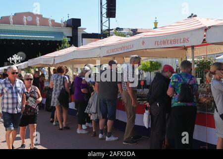 La gente a piedi passato e acquisti presso le bancarelle del mercato di fronte alla fase esterna, Stora scenen, in Liseberg Amusement Park nella città di Göteborg, Svezia. Foto Stock