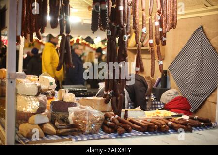 Salumi, formaggi e salumi appendere in vendita su una bancarella al mercato natalizio di Praga. Praga, Repubblica Ceca. Dicembre 2019. Foto Stock