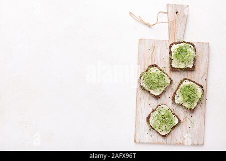 Panini integrali con diffusione di avocado, tofu e microgreen Foto Stock
