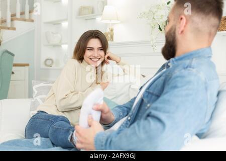 Caring marito dando massaggio ai piedi per sua moglie Foto Stock