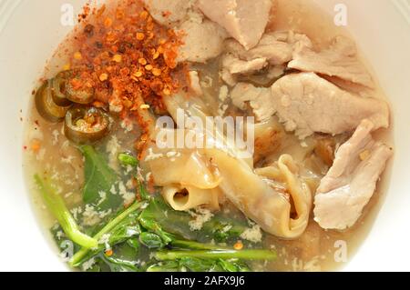 Saltate in padella grande noodle con carne di maiale marinato in salsa di salsa al pepe di medicazione sulla ciotola Foto Stock