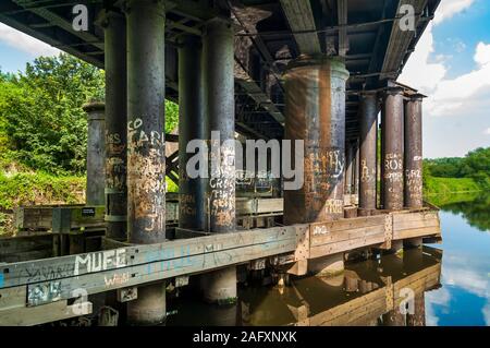 Numerosi graffiti-coperto colonne in ghisa sul lato inferiore del ponte Conisborough, attraversando il fiume Don in Sheffield a Doncaster treno linea Foto Stock