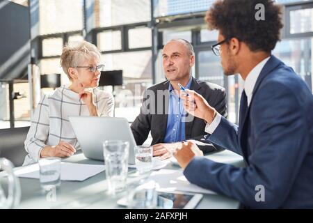 Un gruppo di uomini di affari che in una riunione per discutere e pianificazione di un progetto Foto Stock