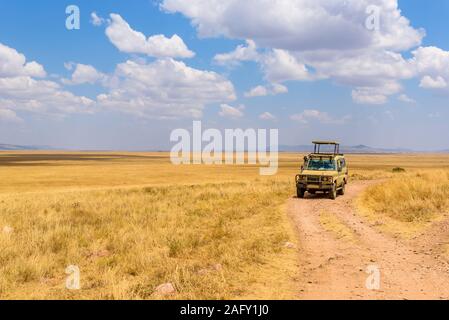 Safari turisti su game drive con Jeep auto nel Parco Nazionale del Serengeti nel bellissimo paesaggio paesaggio, Tanzania, Africa Foto Stock