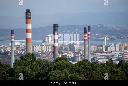 Coruna / Spagna - 15 dicembre 2019: Repsol raffineria di pile di fumo torre sopra la città di CORUNA in Spagna Foto Stock